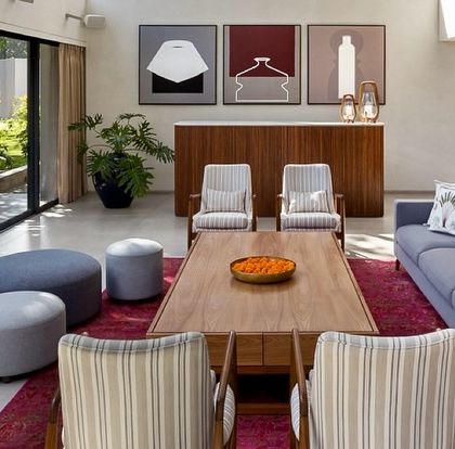 Another angle of the Mango Orchard House living area, where we paired a modern sofa with classic striped armchairs. The deep red rug adds a layer of warmth and color, grounding the seating arrangement.