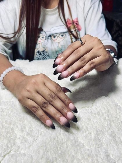 A black ombre or 'smoke' effect on the tips of almond-shaped nails. This is a subtle yet edgy look that is very popular with clients.