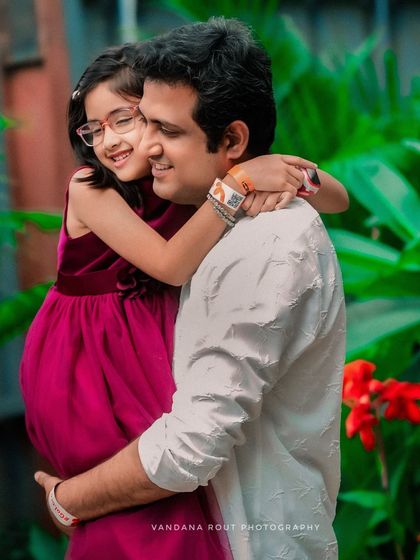 A daughter hugs her father, who is also the expectant father in this maternity shoot. It’s a beautiful portrait of a growing family's love.