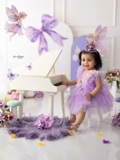 Let us bring your child's birthday dreams to life with our creative themed shoots. This enchanting fairy-themed first birthday setup, complete with a miniature piano and whimsical purple details, shows how we create a magical world for your little one to explore.