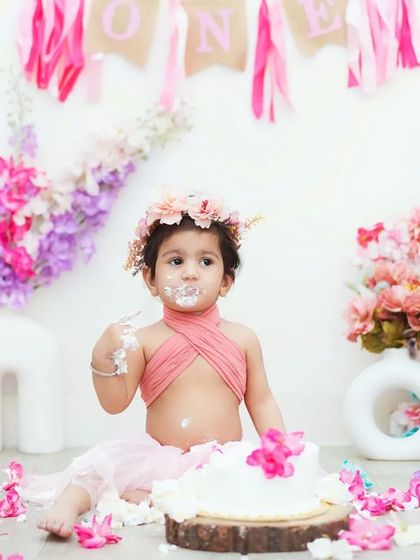A full view of the floral cake smash setup. I coordinate the colors of the cake, outfit, and backdrop for a beautiful, cohesive look.