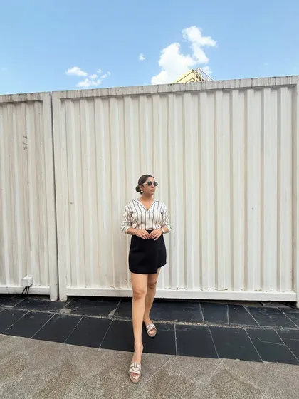 This look is perfect for a smart-casual setting. The combination of a classic striped shirt and a modern skort is comfortable yet polished. I help clients build a wardrobe full of such easy-to-wear outfits.