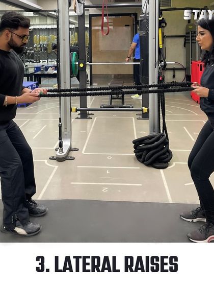 Using resistance bands for partner lateral raises adds a new challenge and requires teamwork to maintain tension and form.