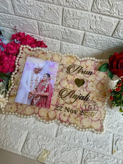 We can turn your wedding varmala and favorite photo into a beautiful memory frame. This 12x16 inch resin frame uses the original flower petals as a backdrop and pearls from the varmala for the border, creating a complete and sentimental keepsake.