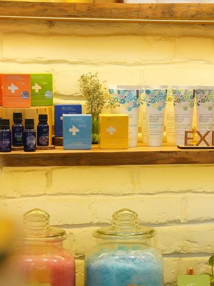 A closer look at our product shelves, featuring colorful bath salts in glass jars and a curated selection of our "Exfoliate" range.