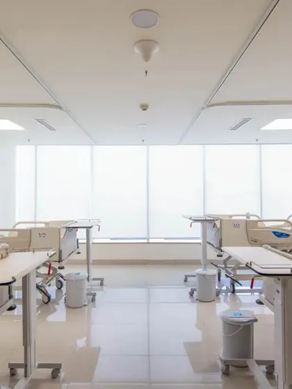 This general ward is designed to maximize natural light with a wall of windows. The bright, open space helps reduce feelings of confinement and creates a more positive environment for patients in a multi-bed setting.