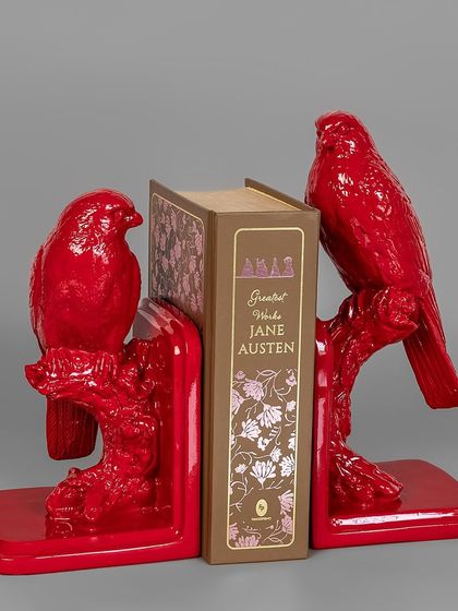 For the book lover, I have these 'Whispering Woods' bookends. Shaped like birds on a branch and finished in a vibrant red, they are a functional and artistic way to organize your favorite books.