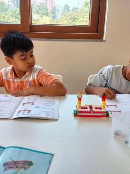 Students at our Whitefield center work on their projects, using both LEGO bricks and workbooks to solidify their learning.