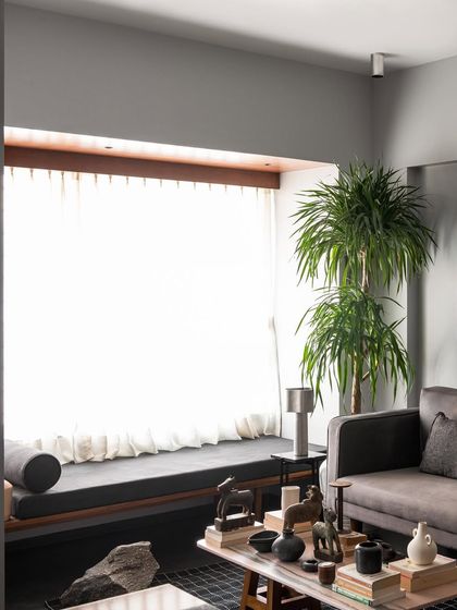 A view of the living room highlighting the window seat I designed. It provides a long, comfortable perch to enjoy the bright light from the large window, with the main seating area arranged for conversation.