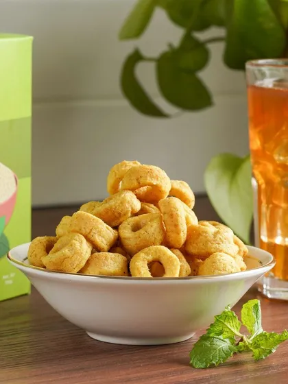 A close-up of the crunchy quinoa rings, paired with a glass of iced tea, suggesting a perfect evening snack.