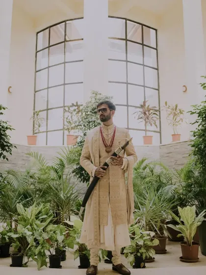 A groom's portrait is about capturing his presence and personality. Here, we used the architectural lines and lush greenery to frame him, creating a powerful, magazine-worthy shot that speaks of tradition and modern style.
