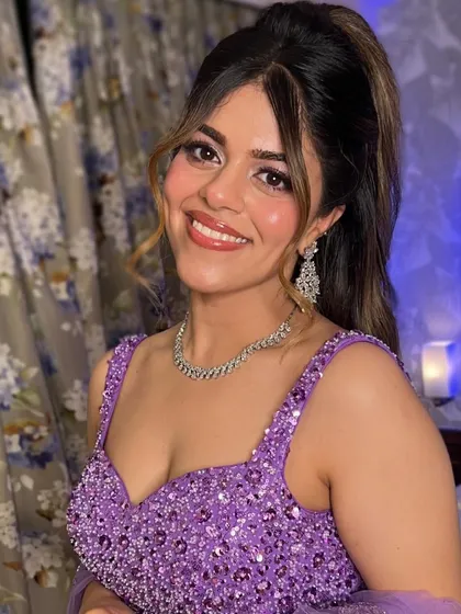 A happy and radiant smile from this bride, ready for her cocktail party in a sparkling purple lehenga.