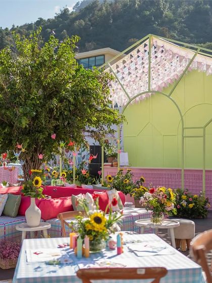 A cheerful and colorful seating area at our 'Picnic in the Mountains' mehendi, complete with a tree centerpiece and gingham-patterned furniture.