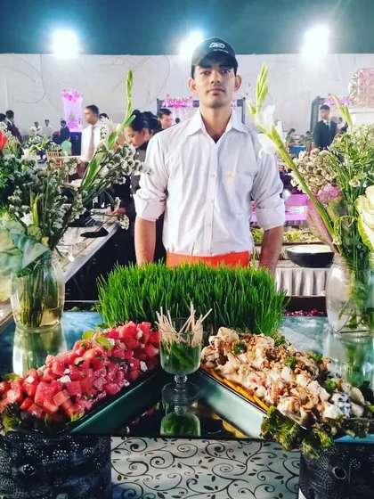 A member of my service team proudly standing behind his salad station, ready to serve guests.