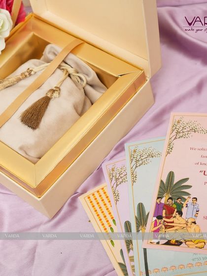 This boxed invitation set for an Upanayanam includes beautifully illustrated cards and a potli bag for gifts. The design thoughtfully combines the announcement with a gesture of hospitality, creating a warm and traditional welcome for guests.