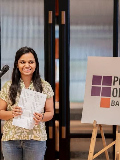 A poet shares her work, her smile reflecting the positive and uplifting energy of the "Break the Boundaries" event.