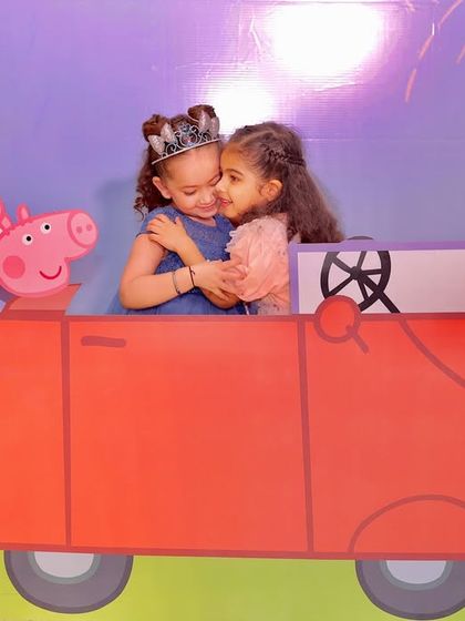 A heartwarming moment at a Peppaland party, where two little princesses share a hug inside the custom Peppa Pig car photo booth. These are the precious memories I love to help create.
