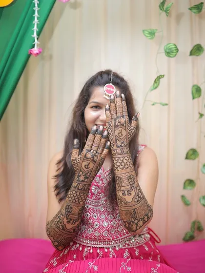 A playful peek-a-boo pose that highlights the beautiful bridal mehendi. Her happiness is infectious.