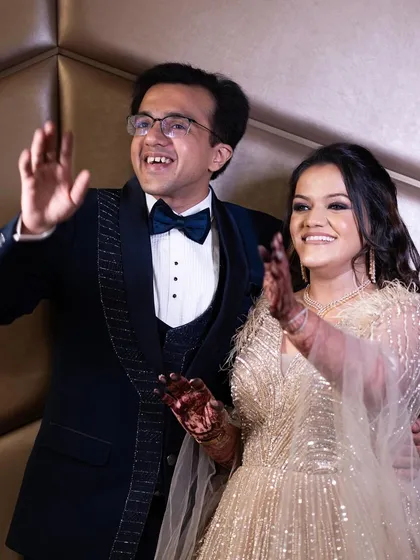 A celebratory wave from the happy couple. Her makeup is designed to look flawless and radiant all night long.