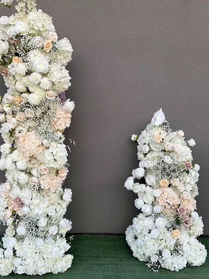 For weddings and formal events, I create elegant floral pillars like these. Made with high-quality artificial white roses, hydrangeas, and other mixed flowers, they are perfect for decorating a stage, entrance, or wedding aisle. They provide a classic look that lasts through the entire event.