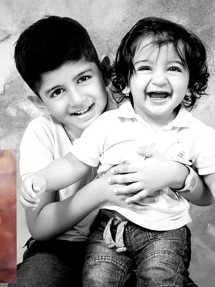 A black and white edit highlighting the pure joy between two brothers during a milestone photoshoot. The laughter and connection here are absolutely priceless.