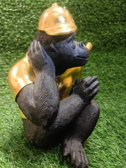 A side view of the chimpanzee showpiece, highlighting its relaxed and confident pose.