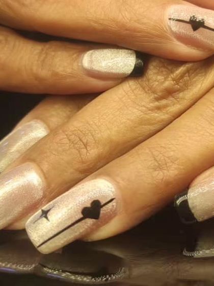 A close-up of the black-tipped French manicure, detailing the fine line art with a heart.