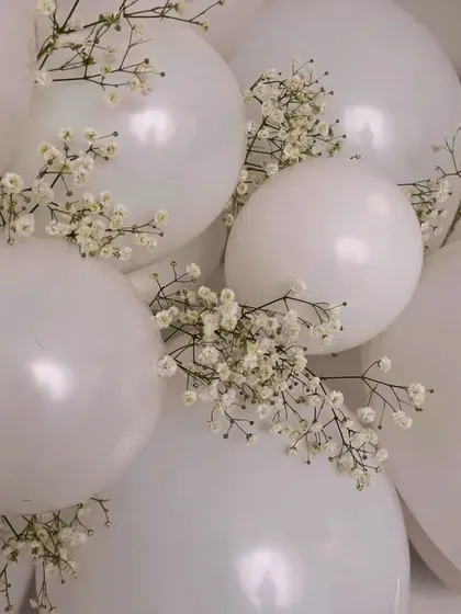 Details matter. Here, I've added delicate sprigs of baby's breath to simple white balloons. This small touch elevates the decor, adding a bit of natural texture and elegance to a classic balloon arrangement.
