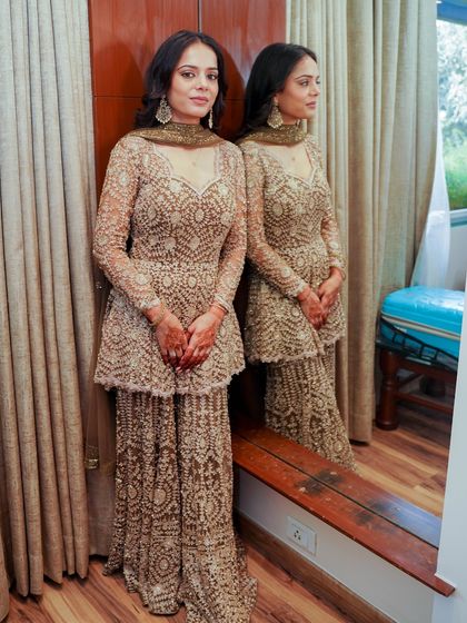 A reflection shot that captures the full effect of this glamorous look. The dewy skin and bronze eyes create a sophisticated and modern vibe.