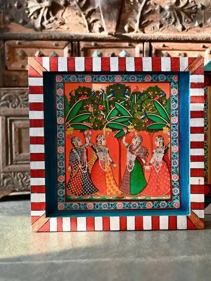 The bottom block of the set, showing gopis in a lush grove. The red and white striped border adds a playful, contemporary touch.