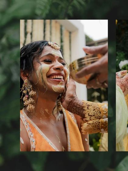 A close up of a smiling bride as a family member gently applies turmeric paste to her cheek. This shot highlights the traditional and intimate aspect of the Haldi ritual.