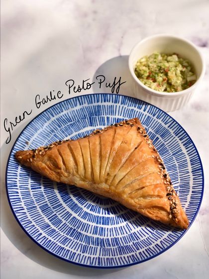 The Green Garlic Pesto Puff is a celebration of winter produce. Our flaky puff pastry is filled with a vibrant green garlic pesto, sweet peas, and potatoes, making it a delicious vegetarian option.