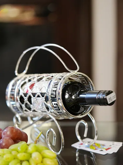 My silver-plated wine holder, with its intricate latticework and Greek key pattern, is a stylish way to present a bottle of wine as a gift or on your festive table.