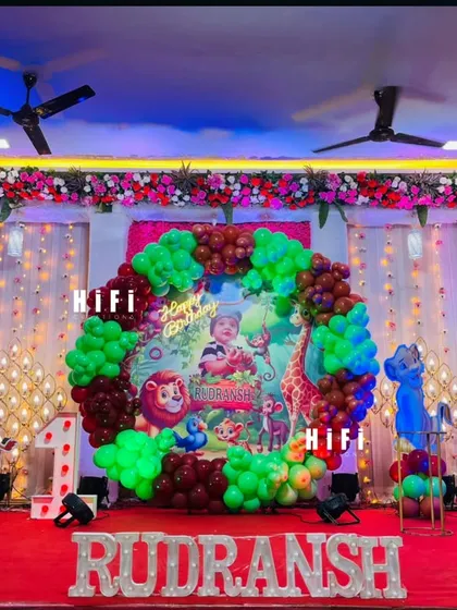 A full stage setup for a jungle-themed first birthday, showing how we can transform a hall into a vibrant forest.
