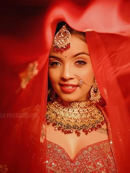 A joyful bridal portrait, capturing a bright smile as she holds her veil. This image is full of life and happiness.