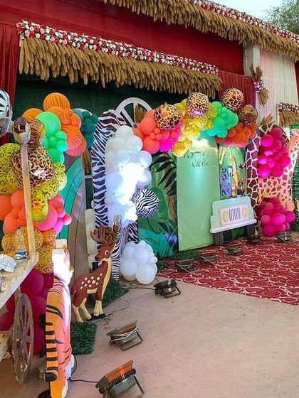 A detailed shot of the jungle party stage, showing a variety of animal props and balloons with different animal prints like tiger, zebra, and giraffe.
