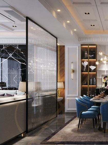 A view from the living room into the opulent dining space, separated by a fluted glass partition that allows light to pass through while creating a sense of division.