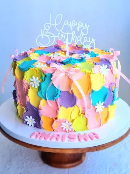 Another view of the painted buttercream cake, showing the personalized name.