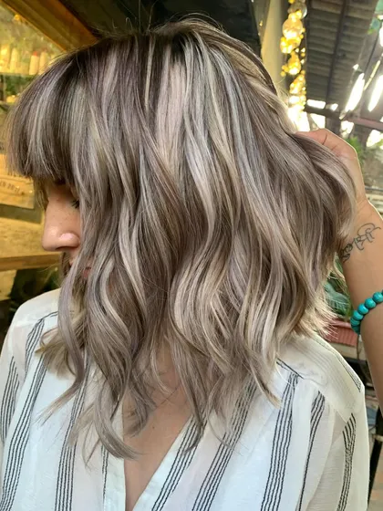 A side view of the blonde bombshell bob with bangs. The cut and color are a perfect match.