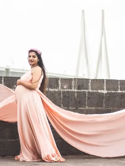 This elegant peach maternity gown features a double trail for added flair. It’s an excellent choice for capturing stunning portraits with an urban backdrop, like the Mumbai sea link seen here.