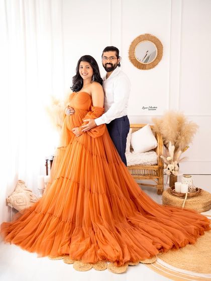 A beautiful full-length portrait of the couple in our boho-chic studio. The warm orange gown and coordinated outfits create a harmonious and stylish look.