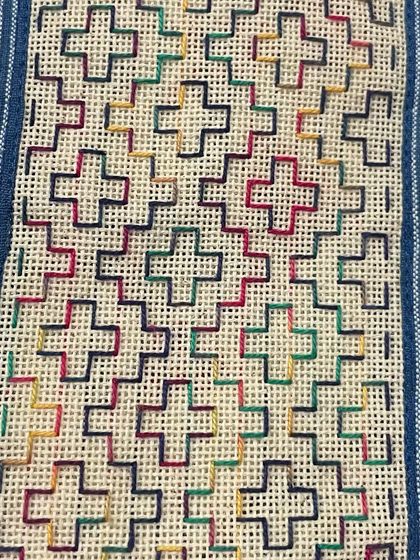 A multi-colored phone insert with a pattern reminiscent of traditional weaving.