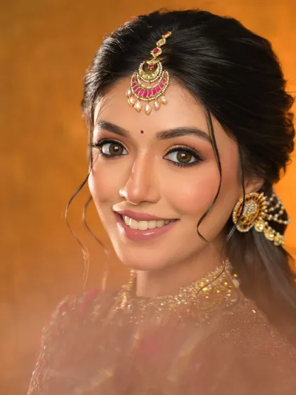 A happy, smiling bride. Her natural-looking makeup features defined eyes and a glossy nude lip.