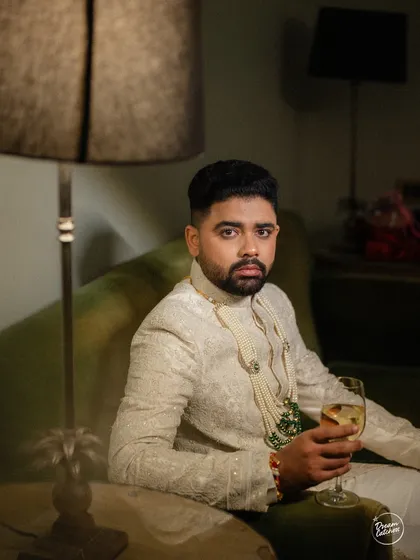 A stylish, moody portrait of the groom, capturing a moment of calm and contemplation.