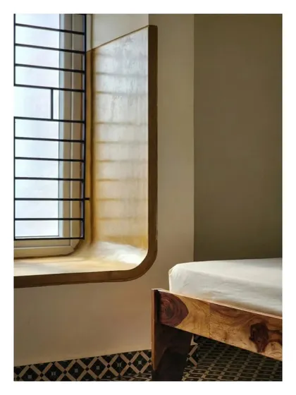 A curved, built-in window seat finished in polished oxide. This architectural intervention transforms a simple bedroom window into a unique, contemplative space, demonstrating our focus on creating personalized nooks that enhance the living experience.