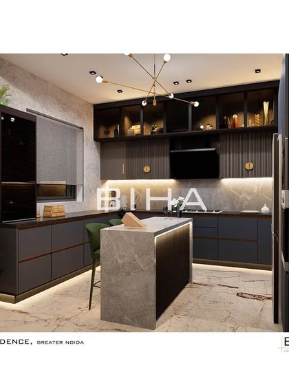 This view of the Greater Noida kitchen showcases the island and the extensive counter space. The design incorporates a built-in oven and microwave tower for ergonomic efficiency, while the brass-accented light fixture adds a sculptural element overhead.