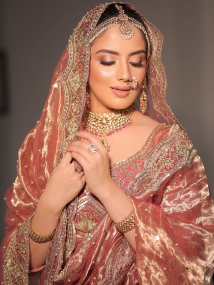 A moment of reflection. The soft lighting highlights the intricate details of the velvet shawl and the bride's jewelry.