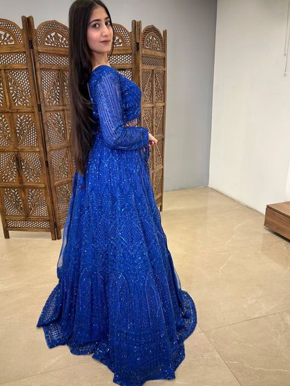 The side view of the royal blue lehenga shows off its beautiful color and the way the light reflects off the sequins.
