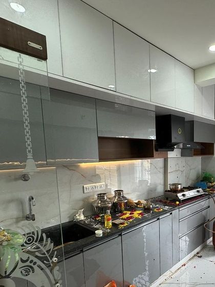 Another angle of a newly finished modular kitchen, showing the integrated chimney and ample overhead storage. The design balances aesthetics with the practical needs of a busy kitchen.