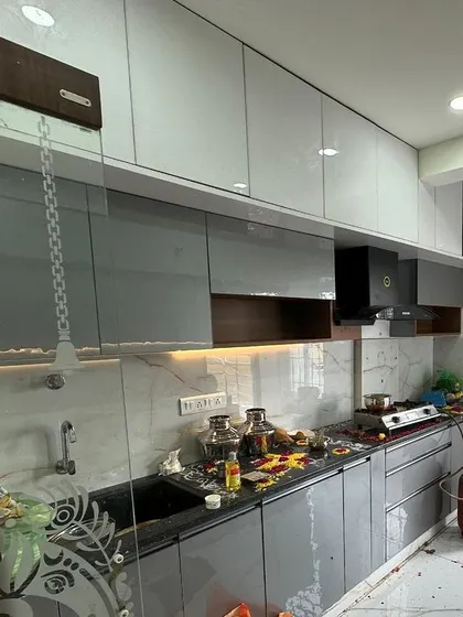 Another angle of a newly finished modular kitchen, showing the integrated chimney and ample overhead storage. The design balances aesthetics with the practical needs of a busy kitchen.